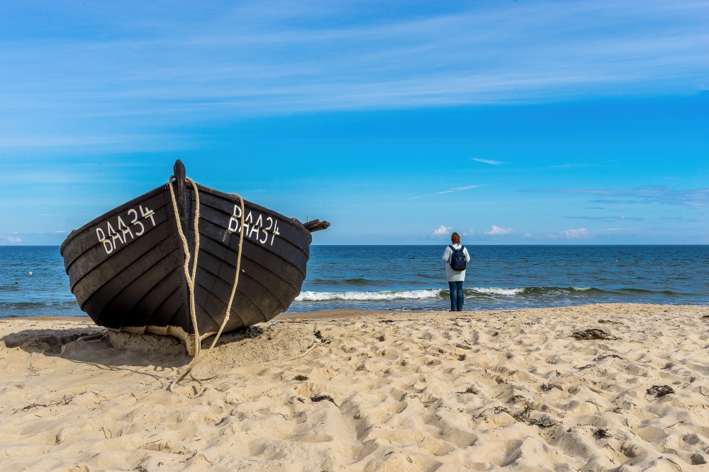 Strandfoto mit Person und Boot